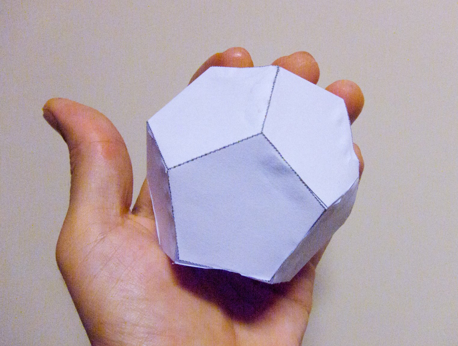 Paper dodecahedron held in hand